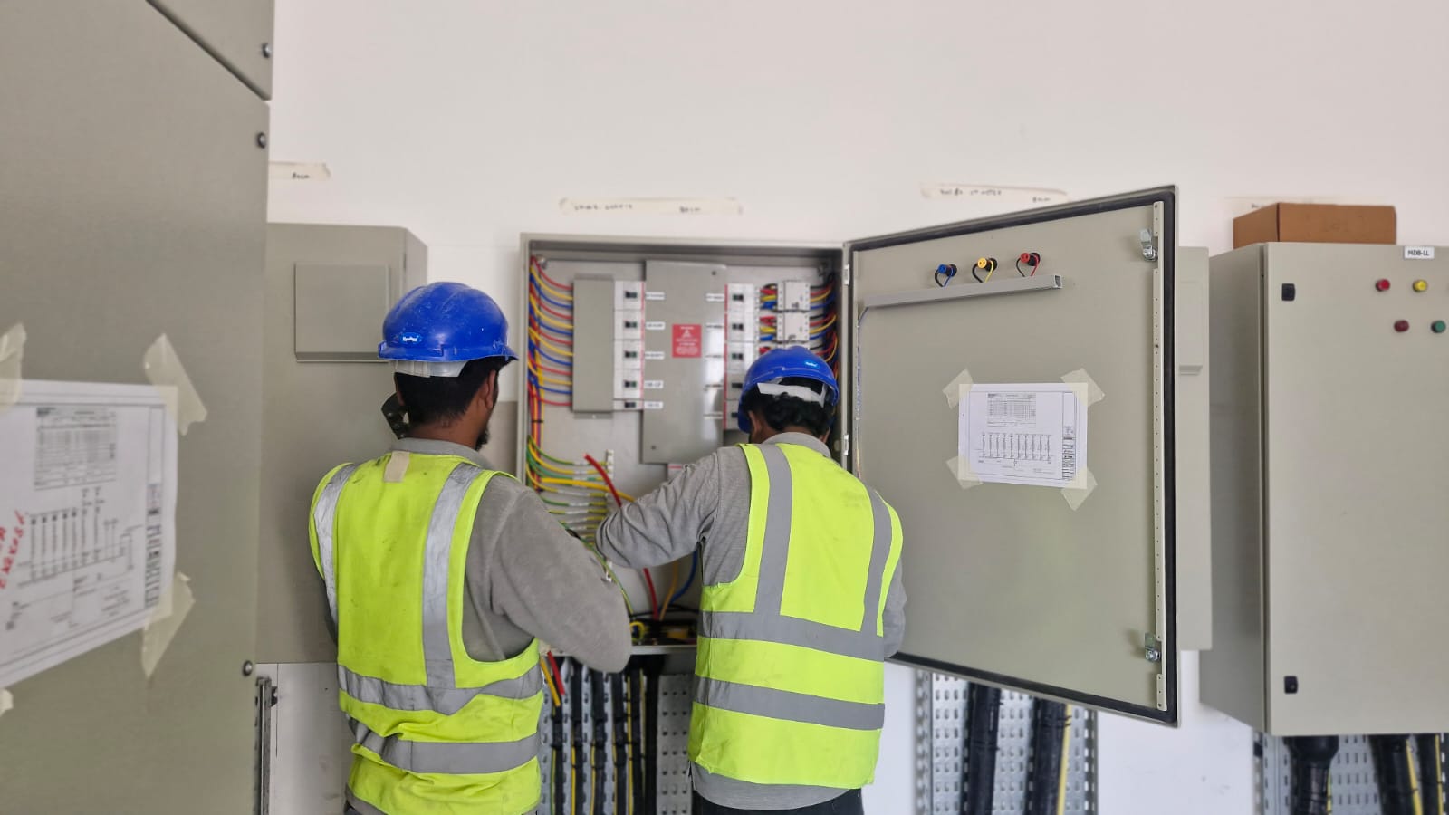Modern office building with glass facade showing collaborative workspaces inside during daytime